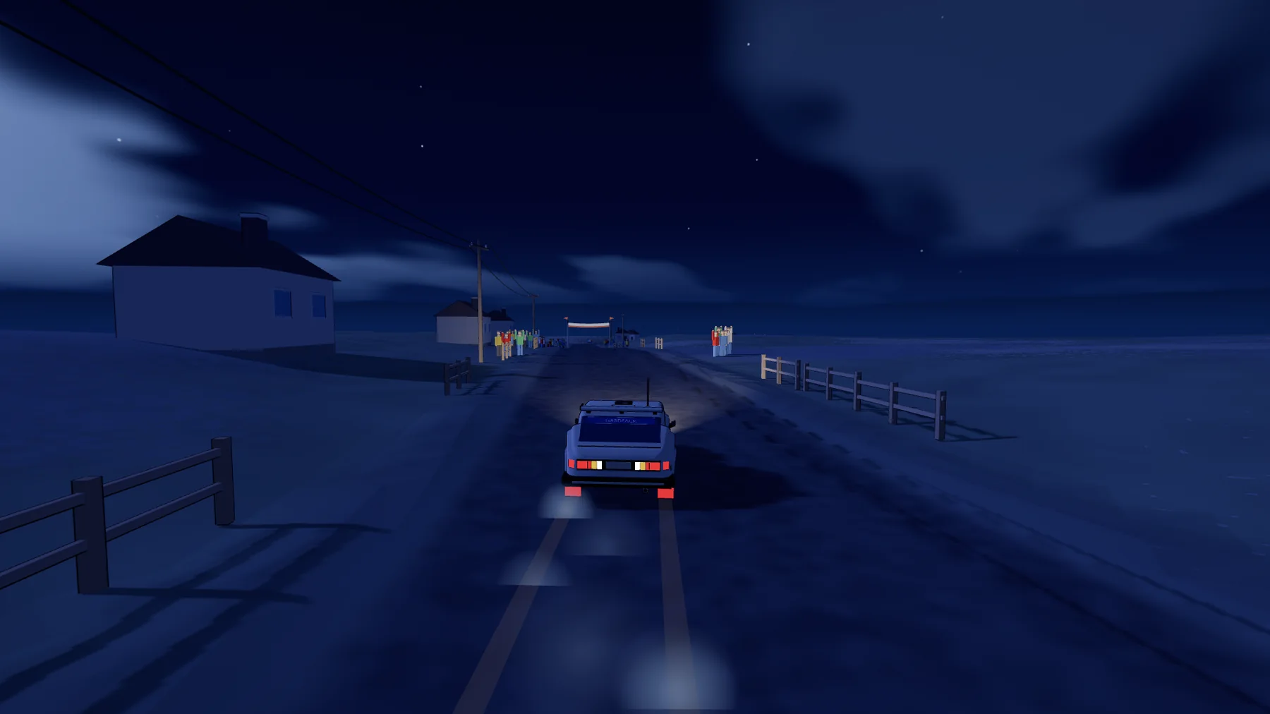 A rally car at night on a road past white houses, headlights on, spectators at a gate ahead.